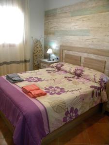 马拉加El Valdes House的一间卧室配有一张紫色和紫色花卉床