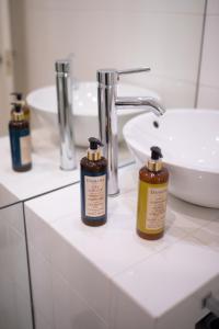 里斯本幸福里斯本公寓 - Bairro Alto的浴室提供三瓶肥皂和水槽