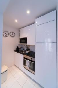 里斯本幸福里斯本公寓 - Bairro Alto的厨房配有白色橱柜和冰箱。