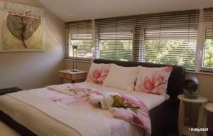 宰斯特Bed and Breakfast Valckenbosch的一间卧室,床上有粉红色的鲜花