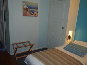 马尔康巴勒尔杜克鲁瓦赛酒店的一间小卧室,配有一张床和一把椅子