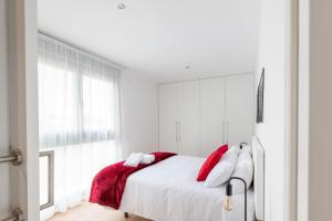 马德里Cituspace Arturo Soria的一间卧室配有红色和白色枕头的床