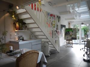 宰斯特Bed and Breakfast Valckenbosch的厨房设有楼梯,配有桌椅
