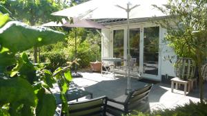 宰斯特Bed and Breakfast Valckenbosch的庭院配有遮阳伞和桌椅。