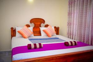 蒂瑟默哈拉默Tissa Rainbow Guest & Yala的一间卧室配有一张带色彩缤纷枕头的大床