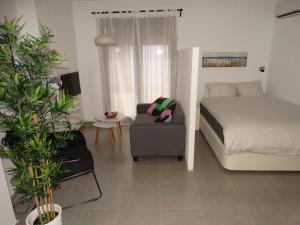马拉加Málaga Apartamentos - Jinetes, 23的一间卧室配有一张床、一张沙发和一把椅子