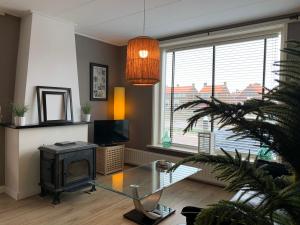 德科赫Texelheerlijk 4的客厅设有玻璃桌和壁炉