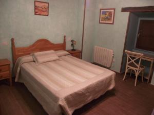 阿塔普埃尔卡El Rincón de Atapuerca的卧室配有1张床、1张桌子和1把椅子