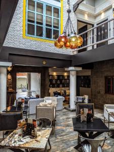 瓜亚基尔Cedros Inn Boutique Hotel的一间带桌椅和吊灯的餐厅