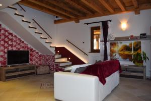 塔尔维西奥Casa Vacanza CADORNA RESIDENCE的客厅配有白色沙发和楼梯。