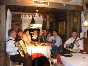 圣莱奥纳尔多因帕西里亚Hotel Gurschler的一群人坐在桌子旁,拿着乐器