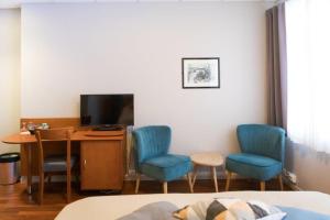 Ytterland奥勒松机场酒店的配有书桌、两把椅子和电视的房间