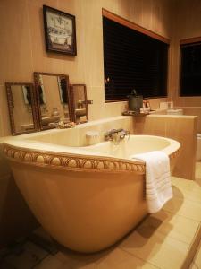 鲁德普特Bristow Luxury Suites With Back Up Power and Free Wi-Fi的带窗户的浴室设有大浴缸