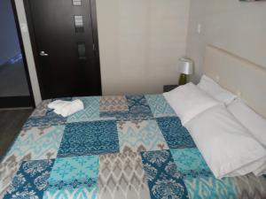 里奥班巴Illari Hotel的一间卧室配有床,床上装有被子