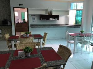 戈亚尼亚Hotel Oliveira的一间带桌椅的用餐室和一间厨房