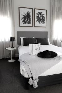 悉尼St Marks Randwick的一间卧室,配有一张床,上面有帽子