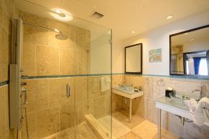 黎明海滩Coral Beach Club Villas & Marina的一间带玻璃淋浴和水槽的浴室
