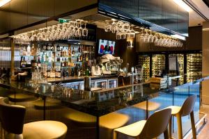 悉尼布兰克桑姆酒店的酒吧设有桌椅和酒杯