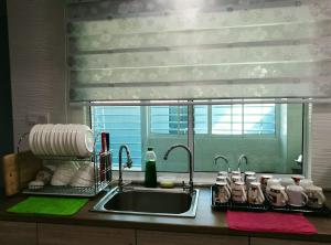 哥打京那巴鲁Leisure homestay@Kota Kinabalu的带水槽的厨房台面和窗户