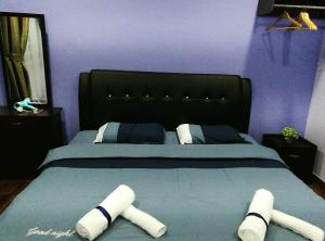 哥打京那巴鲁Leisure homestay@Kota Kinabalu的一间卧室配有一张大床和黑色床头板