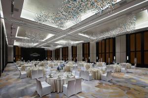 萧山杭州湘湖逍遥庄园的一个带白色桌子和白色椅子的大型宴会厅