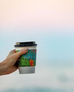 檀香山威基基VIVE酒店的手持咖啡杯在天空中