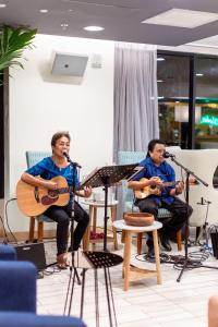 檀香山威基基VIVE酒店的坐在椅子上弹吉他和音乐的两个人