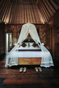 乌布KERAMAN SUITE UBUD的一间卧室配有一张带蚊帐的床