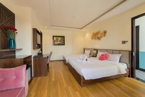 会安晃特林酒店的一间卧室配有两张带粉红色鲜花的床。