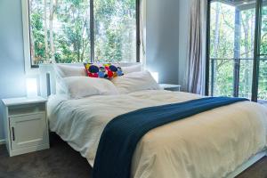 马莱尼Treetops Haven的一间卧室设有一张大床和大窗户