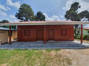 Kampong Alor GajahIkhlas Roomstay的一间棕色的小房子,设有车库