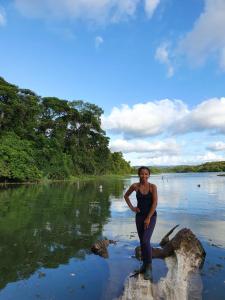 科隆Jungle Eco Reserve的站在水中的岩石上的女人