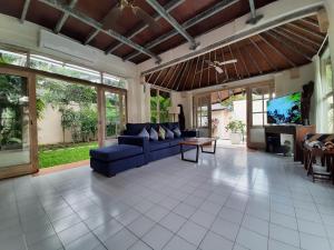 塞米亚克巴厘岛椰子别墅的客厅配有蓝色的沙发和电视