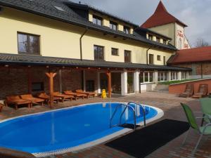 Horní TěrlickoWellness Hotel Fridrich的一座带房子的建筑前的游泳池