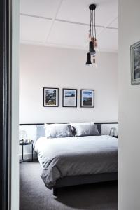 墨尔本St Kilda Beachfront Penthouse的白色卧室配有一张床,墙上有三张照片
