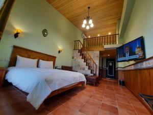五结绿也渡假庄园的一间带大床和楼梯的卧室