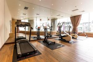 屏东县鮪魚家族飯店-屏東館的健身房,配有一系列跑步机和健身自行车