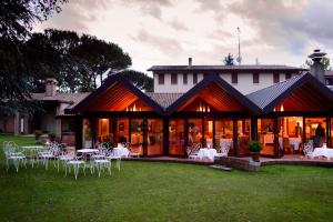 皮耶韦迪索利戈洛里斯公园餐厅-酒店的草丛中带桌椅的建筑