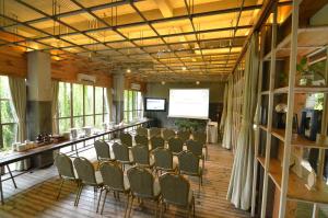 日惹普拉维塔玛格林霍斯特精品酒店的一间会议室,配有椅子和一个带屏幕的讲台
