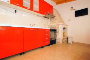 尼亚卢卡Getaway Beach House的一间厨房,内设红色橱柜和炉灶