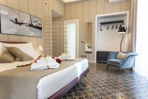卡塔尼亚B&B Palazzo Perrotta的配有一张床和一把椅子的酒店客房