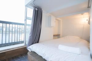东京东京第二章旅舍的一间卧室设有一张床和一个大窗户