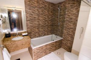 马斯喀特Al Murooj Grand Hotel的带浴缸、盥洗盆和卫生间的浴室