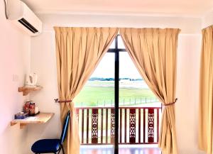 瓜拉丁加奴安特朗西酒店的客房设有带窗帘和椅子的窗户。