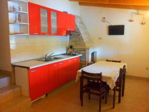 尼亚卢卡Getaway Beach House的厨房配有红色橱柜、桌子和水槽