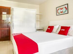 萨尔瓦多OYO Hotel Stella Maris - Salvador的卧室配有带红色枕头的大型白色床