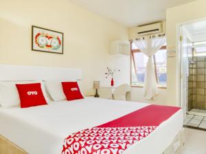 萨尔瓦多OYO Hotel Stella Maris - Salvador的卧室配有带红色枕头的大型白色床