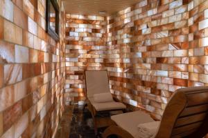 普里什蒂纳普里什蒂纳瑞士钻石酒店的一间设有木墙和两把椅子的房间