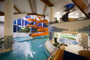 凯希道库什塔尼Kehida Termál Resort & Spa的度假村的水上滑梯,设有两个游泳池