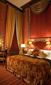 贝尔法斯特商业酒店的一间卧室设有一张带红色墙壁的大床